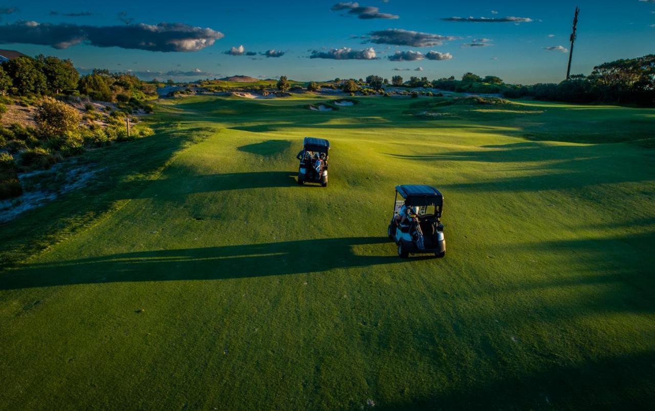 Pullman Magenta Shores Resort Entrance Екстер'єр фото Golf carts on the green